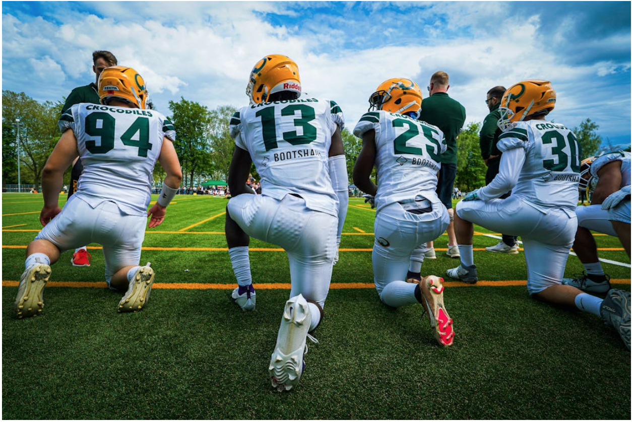 Football players in uniform crouching on the field